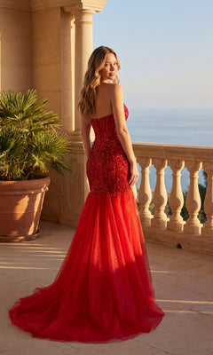 A woman wearing the Chicas C345 long prom dress with a strapless sequin mermaid design and fitted silhouette stands on a stone balcony overlooking the sea.