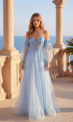 A woman in the Chicas C358 long formal dress in sky blue, featuring an off-shoulder corset bodice and floral embroidery, stands on a stone terrace overlooking the ocean.