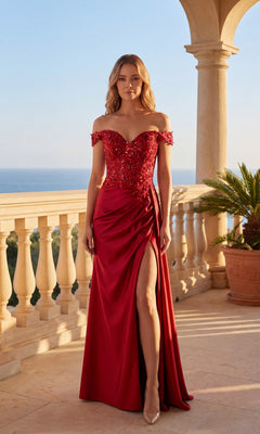 On a sunlit terrace with sea views and palm plants, a woman wears the Chicas C362 long prom dress in apple red, featuring an off-the-shoulder style, sequin details, sweetheart neckline, and thigh-high slit.