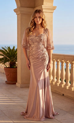 A woman in the Chicas C364 Long Formal Dress in rose gold, featuring floral embroidery and a leg slit, stands on a stone terrace with columns and a potted plant overlooking the sea.