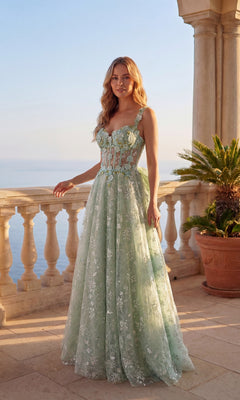 A woman in a sage Long Prom Dress: Chicas C370 with floral lace embroidery stands on a stone terrace, ocean and palm plants in the background.