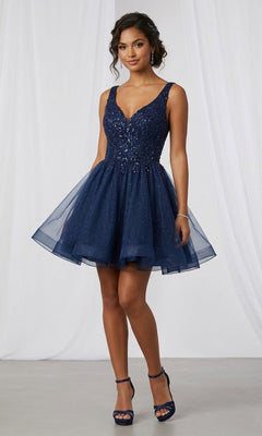 A woman wearing the Chicas C376 short homecoming dress in navy, featuring a sleeveless fitted bodice and flared skirt adorned with sparkly embellishments on glitter tulle, paired with matching high-heeled sandals.