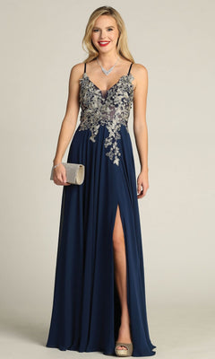 A woman wearing the Lace-Up Open-Back Long Prom Dress: Chicas C5124 in navy blue with silver floral embroidery, spaghetti straps, a thigh-high slit, and holding a silver clutch.