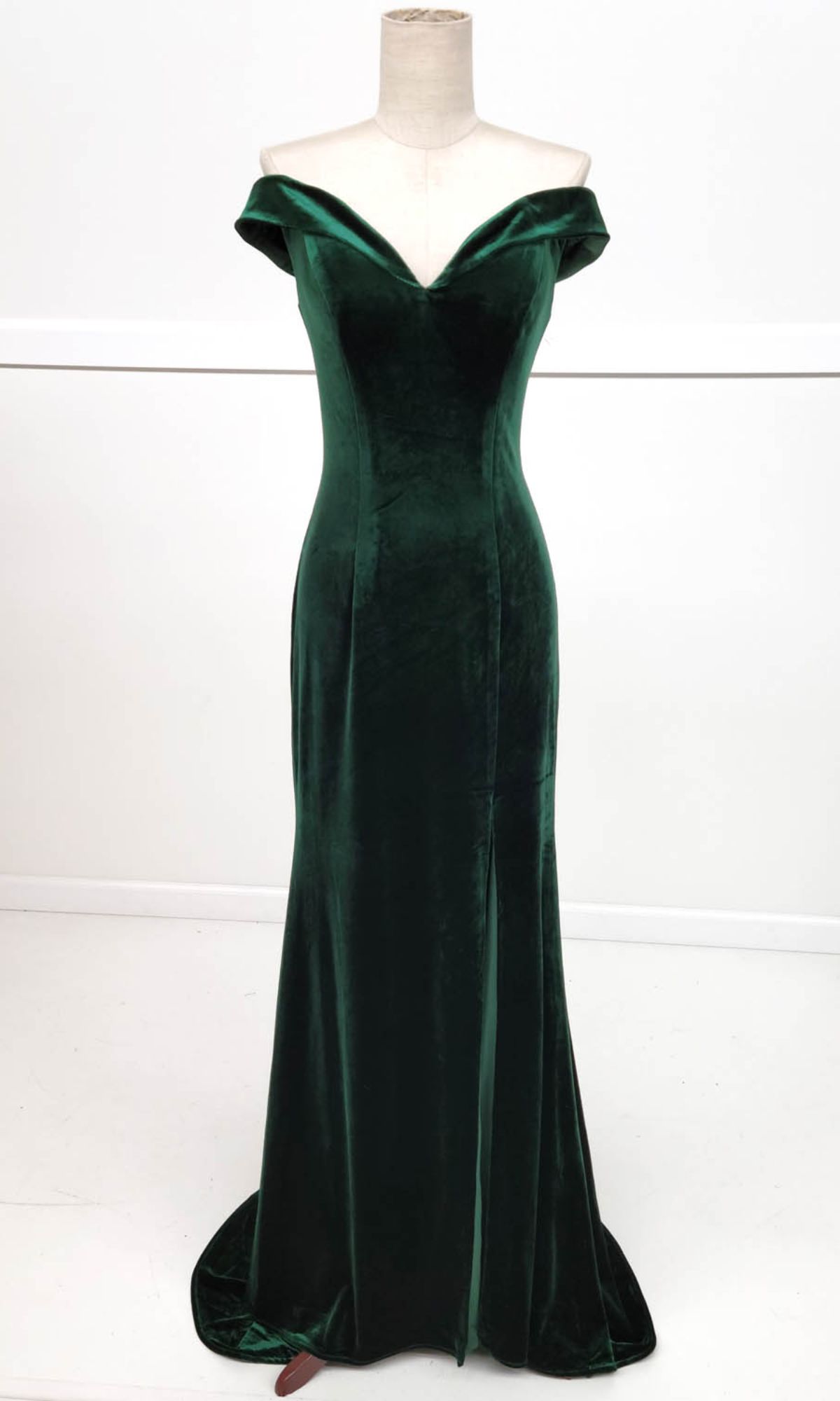 The Chicas C6532 Off-the-Shoulder Long Prom Dress in dark green velvet features a fitted bodice and flared floor-length skirt, elegantly shown on a dress form.