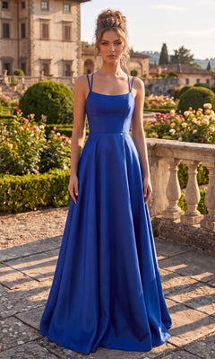 A woman wearing the Long Prom Dress: Chicas C7070 in Royal stands outdoors on a stone path, with a historic building and manicured gardens in the background.
