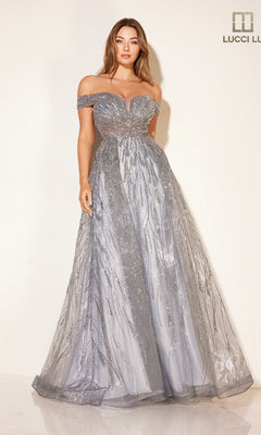 A woman stands against a plain light background wearing the Pastel Blue Prom Ball Gown Lucci Lu C8044, featuring an off-the-shoulder design with a sheer, glittery overlay and floor-length skirt.