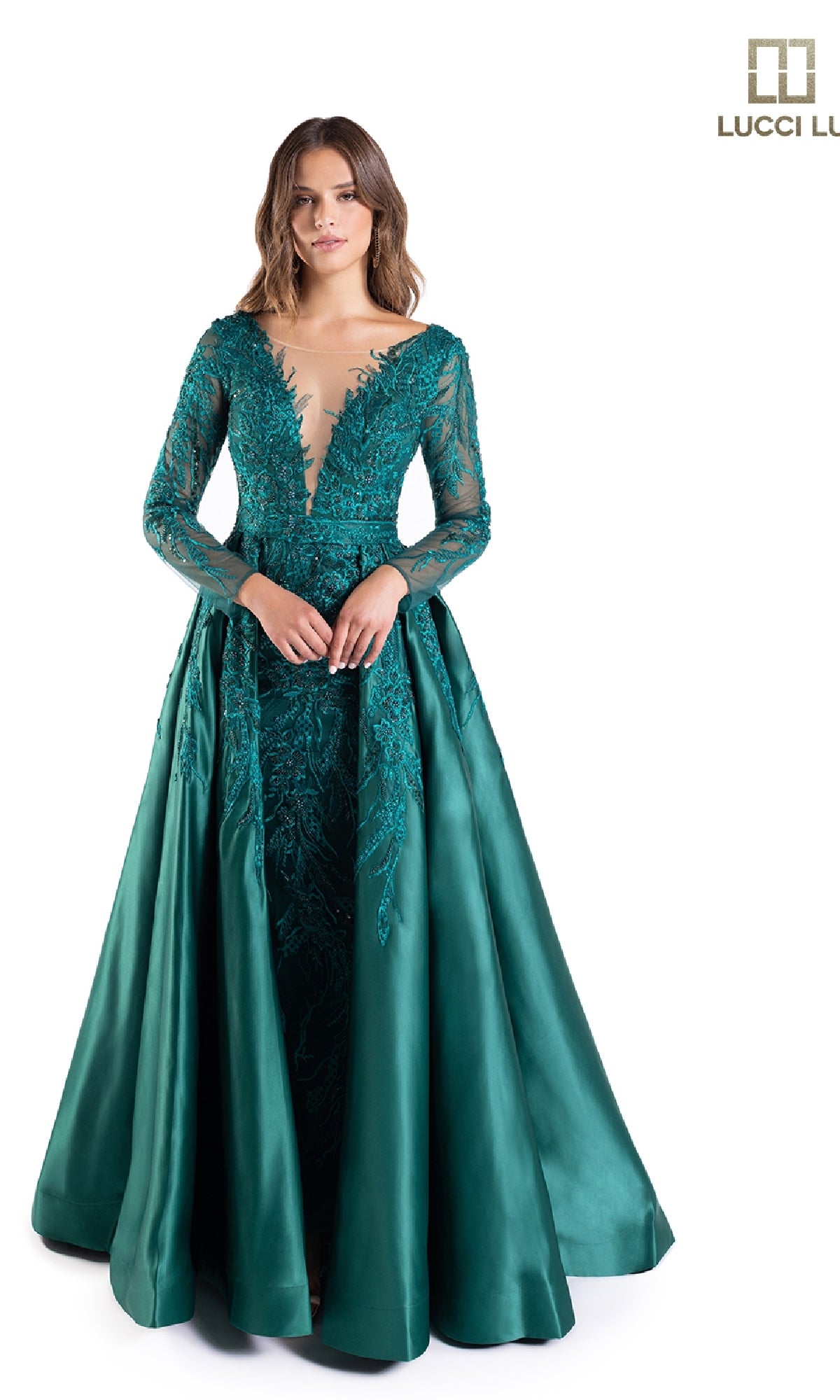 A woman stands against a white background wearing the Lucci Lu C8045, a teal long formal dress featuring lace detailing and a plunging v-neckline.