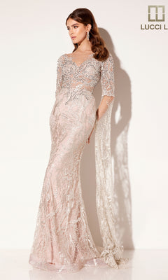Woman wearing the Lucci Lu C8073 long formal dress—fitted, floor-length, pastel pink lace with silver sequins and sheer sleeves—posing against a light background.