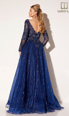 A woman with long wavy hair models the Lucci Lu C8076, a floor-length navy blue prom dress with long sleeves, lace details, and a plunging v-neckline, standing against a plain background.