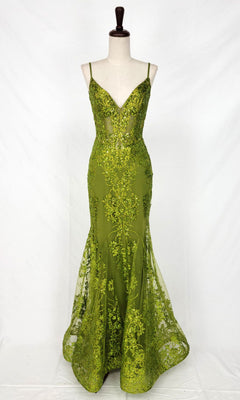 The Chicas C813 Long Glitter-Print Prom Dress is an olive green, floor-length mermaid gown with thin straps, deep V-neckline, sequin embroidery, and a sheer corset waist. Shown on a dress form against a plain white backdrop.