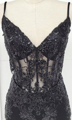 The Sheer-Corset Short Glitter Homecoming Dress C814 is a sleeveless black evening dress with a deep V-neckline, sheer corset-style panels, and detailed sequin and lace embellishments shown on a mannequin.