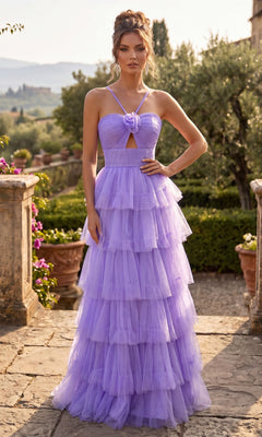 A woman stands outdoors on a stone terrace, wearing the Chicas C837 Long Prom Dress in lavender—a layered tulle ball gown with a corset back and spaghetti straps. Her tiered full skirt flows gracefully amid lush greenery and distant hills in the background.