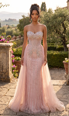 A woman stands outdoors in a garden, wearing the Strapless Long Beaded Formal Dress: Chicas C846, a blush pink gown with sparkling embellishments and a flowing tulle overskirt featuring a sheer tulle overlay.
