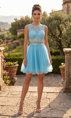Outdoors on a stone patio surrounded by potted plants and greenery, a woman wears the Chicas C9350 Short Homecoming Dress—a light blue, sleeveless design featuring an illusion lace bodice and an elegant A-line tulle skirt—styled with nude heels.