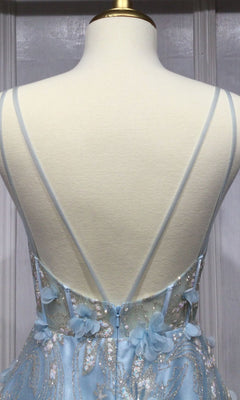 The Ladivine Long Formal Dress CB105 is shown on a mannequin, featuring a light blue ball gown with thin crisscross straps, 3D floral accents, silver embroidery, and a sheer corset bodice.