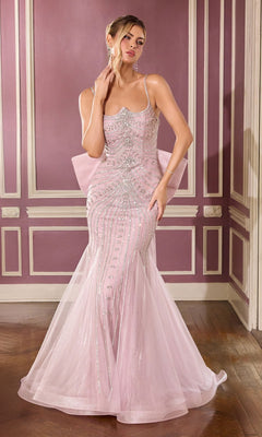 A woman wears the Ladivine CB167 long prom dress in mauve, featuring a fitted silhouette with thin straps, beaded embellishments, sequins, and a dramatic back bow as she stands in an ornate room with mauve walls and white trim.
