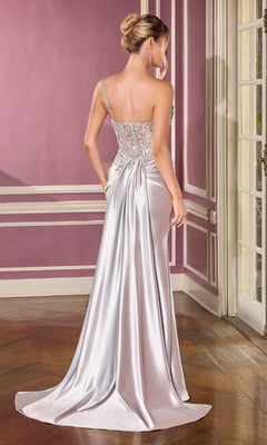 A woman stands with her back to the camera in a formal mauve room, wearing the Long Prom Dress: Ladivine CC0329—an elegant, floor-length gown with a fitted beaded corset bodice and draped satin skirt.