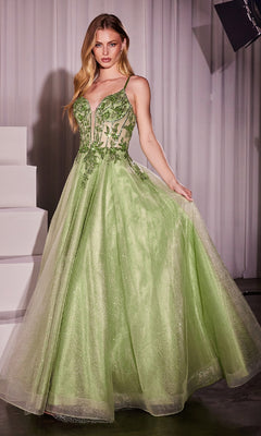 A woman stands indoors near white steps wearing the Sheer-Corset Long Prom Dress: Ladivine CC0881, a light green, floor-length gown featuring a fitted bodice with thin straps, floral appliqué detailing, and delicate beaded embroidery.
