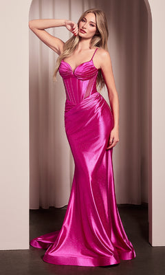 A woman stands in an archway wearing the Ladivine CC2397 Long Corset Glitter Prom Dress, a fitted, floor-length hot pink gown with spaghetti straps and a corset-style bodice.