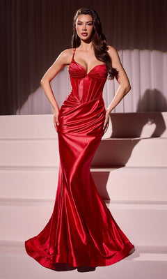 A woman stands on white steps wearing the Ladivine CC2397 Long Corset Glitter Prom Dress, a fitted, floor-length red gown featuring a structured bodice and thin straps.