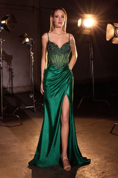 A woman in a sleeveless, beaded-corset long black prom gown (Ladivine CC408) with a high slit stands in front of studio lights in an industrial setting.