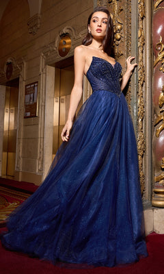 A woman in the Beaded-Bodice Long Prom Dress: Ladivine CC415 stands on a red carpet in an ornate, vintage-style hallway near two elevators.