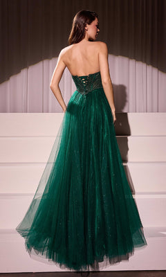 A woman in the Beaded-Bodice Long Prom Dress: Ladivine CC415, a strapless dark green tulle gown with an a-line silhouette and lace-up back, stands facing away by white steps and draped curtains.