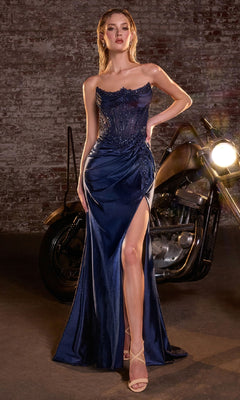 Woman in a navy blue evening gown standing in front of a motorcycle with a brick wall background
