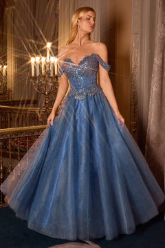 Woman in Ladivine CC471, a blue glitter tulle evening gown, with a chandelier in the background