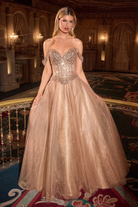 Woman in a gold glitter evening gown standing in an opulent ball room.