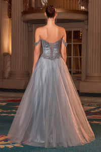 Woman in a glitter tulle evening gown with intricate detailing in an elegant indoor setting.