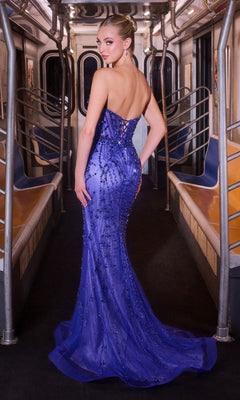 A woman wearing the Long Prom Dress: Ladivine CC8262, a strapless sweetheart neckline sequined purple gown, poses inside an empty subway car, glancing over her shoulder.