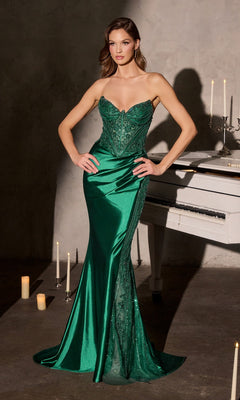 A woman wearing the Ladivine CC9031 long emerald prom dress with a draped satin skirt stands before a white piano, surrounded by glowing candles.