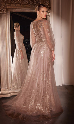 A woman in the Ladivine CD0102 Sheer-Sleeve Long Prom Dress with gold embellishments stands before a large ornate mirror, glancing back over her shoulder.