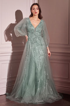A woman stands indoors in the Ladivine CD0102 Sheer-Sleeve Long Prom Dress, a sage green, floor-length gown featuring sheer long sleeves, floral embellishments, and a deep V-neckline.