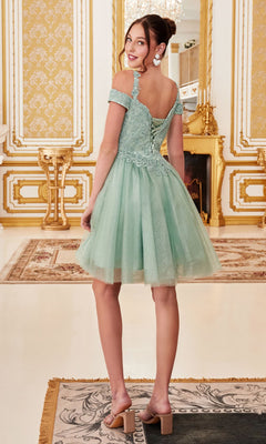 A young woman stands in an ornate room, smiling over her shoulder, wearing the Cold-Shoulder Short Glitter Homecoming Dress CD0132 in light green.