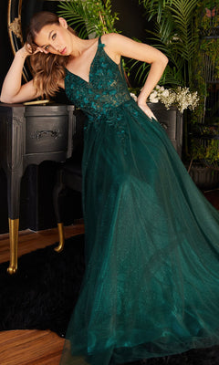 Woman wearing the Glitter Tulle Illusion Prom Dress, Ladivine CD0181, with a floral lace bodice and tulle skirt, leans on a black vanity table surrounded by plants and dark décor.