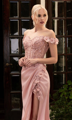 Woman wearing the Off-the-Shoulder Long Sweetheart Prom Dress CD0186, a pale pink gown with floral embellishments, glittery embroidery, and a thigh-high slit, stands before glass-paneled doors.