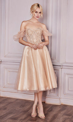 Woman wearing the Puff-Sleeve Tea-Length Prom Dress: CD0187, a shimmery blush pink midi dress with an off-the-shoulder lace bodice, stands before a light gray paneled wall on a wooden floor.
