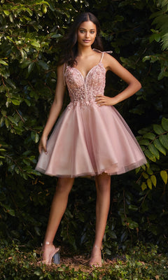 A woman stands outdoors before green foliage, wearing the Glitter-Tulle Short A-Line Prom Dress CD0188 in blush pink with lace details and a glittery tulle skirt, paired with clear high-heeled sandals.