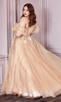 A woman poses elegantly in the Plus-Size Strapless Prom Ball Gown CD0191C, featuring a beige corset-style bodice and tulle skirt with floral details, inside a light-paneled room.