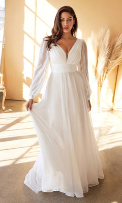 A woman in a Long White Chiffon Formal Dress with Long Sleeves, featuring a deep V-neckline, stands indoors by beige walls and pampas grass—an elegant wedding dress option under $200.