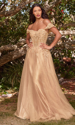 A woman poses confidently outdoors among lush greenery in the Off-Shoulder Long Glitter A-Line Prom Dress CD0198, a gold floor-length gown featuring embroidered lace and sequin embellishments.