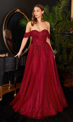 A woman stands indoors in front of a mirror wearing the Off-Shoulder Long Glitter A-Line Prom Dress CD0198—a floor-length red gown with sparkly details, embroidered lace accents, and a fitted bodice.