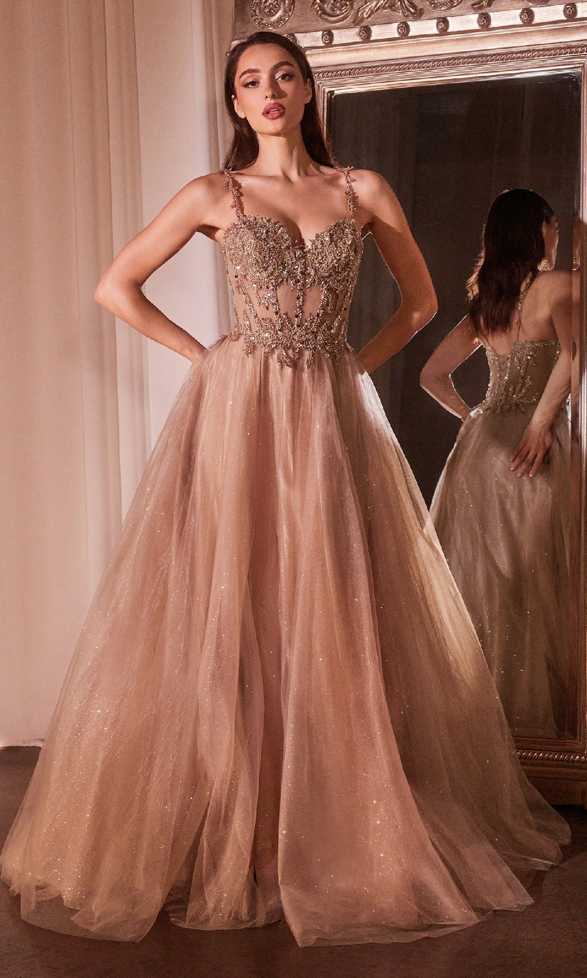 A woman stands before a mirror in the Ladivine CD0234 Glitter-Tulle Long Prom Dress, featuring an embellished sweetheart bodice and a sheer, glitter-tulle overlay flowing into a graceful tulle skirt.