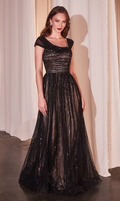 A woman stands indoors wearing the Cap-Sleeve Long Beaded Prom Dress Ladivine CD0238 in Black Nude, featuring a fitted bodice and sparkling details. Elegant curtains in the background highlight this gown's timeless appeal.