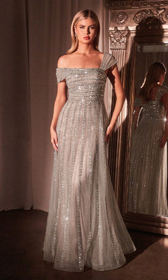 A woman stands before a mirror in the Ladivine CD0238, a cap-sleeve, floor-length beaded prom dress in silver nude, sparkling with sequins and featuring a tulle overlay.