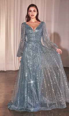 A woman stands indoors in the Ladivine CD0240, a long sleeve beaded formal dress in silver-blue with sequins, sheer sleeves, and a deep V neckline—an elegant evening gown or mother of the bride choice.