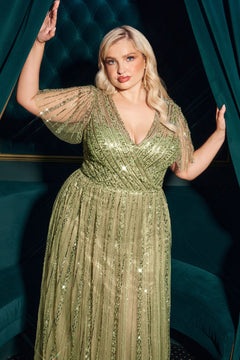 A woman with blonde hair poses between green velvet curtains in a dimly lit room, her Flutter-Sleeve Long Prom Dress: Ladivine CD0241 sparkling as the light catches its beaded, floor-length fabric.