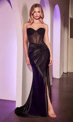 A woman stands indoors in front of white archways, wearing the Lace-Up Strapless Long Prom Dress (Ladivine CD2408) in black featuring a sheer beaded corset bodice, draped satin skirt, and high slit.